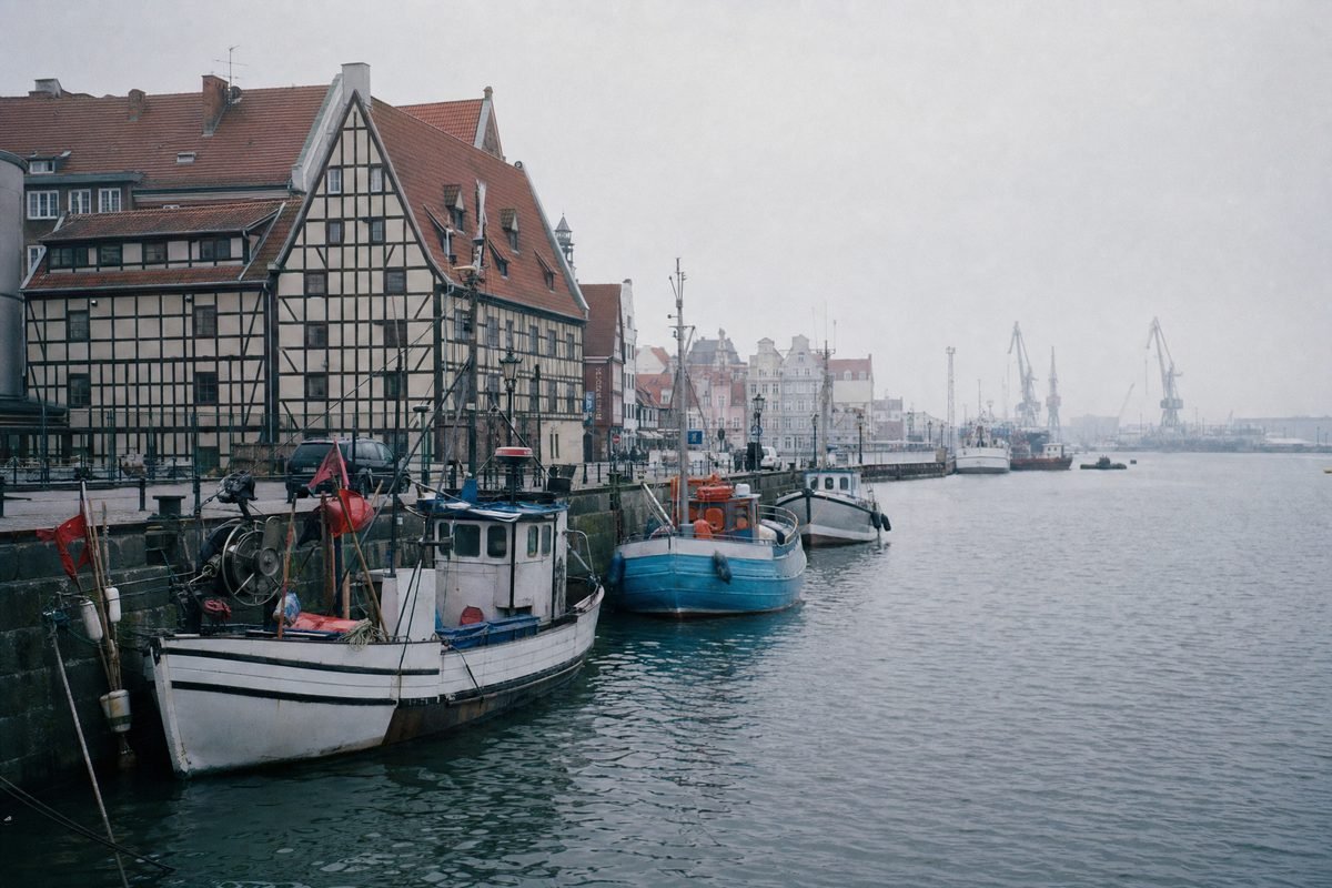A harbour quay with fishing boats and old-town warehouses