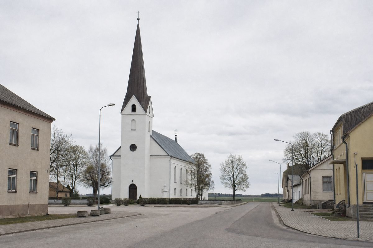A small-town square with a modest church and low buildings