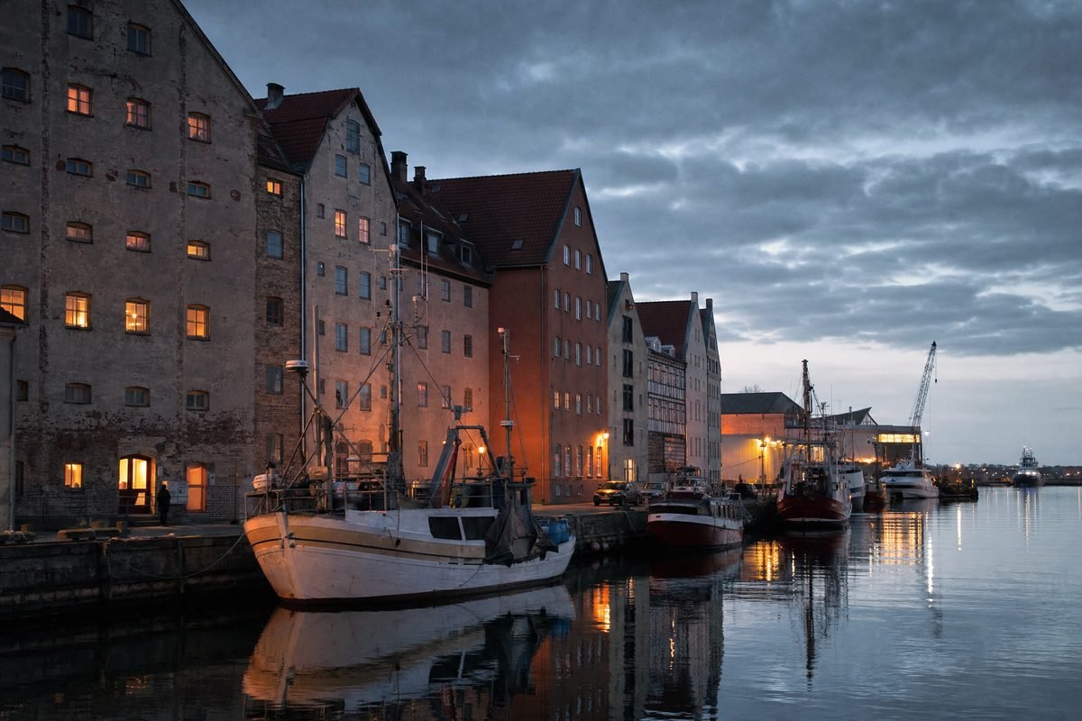 A harbour quay at dusk with lit windows
